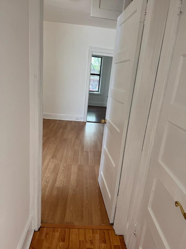 72-53 65th Place Queens, NY 11385 - Photo 5 of 7 Hallway featuring light wood-type flooring and baseboards