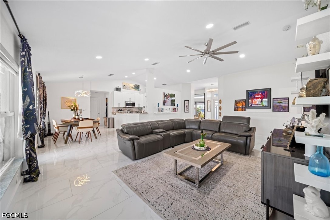 22 Nelson Road South Cape Coral, FL 33991 - Photo 12 of 43 a living room with furniture kitchen view and a chandelier