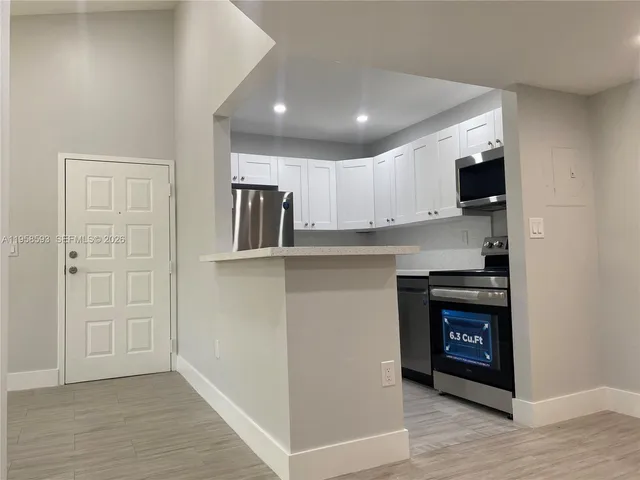 a kitchen with cabinets and wooden floor