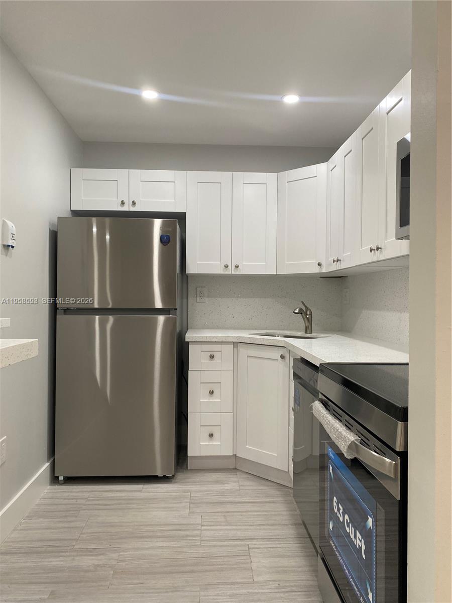 7175 Northwest 179th Street, Unit 302 Hialeah, FL 33015 - Photo 13 of 49 a kitchen with appliances cabinets and a sink
