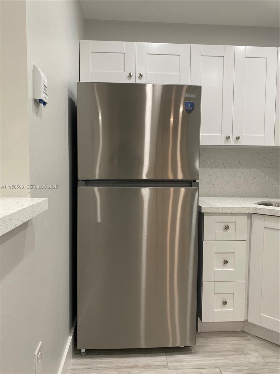 7175 Northwest 179th Street, Unit 302 Hialeah, FL 33015 - Photo 15 of 49 a view of a refrigerator in kitchen and white cabinets