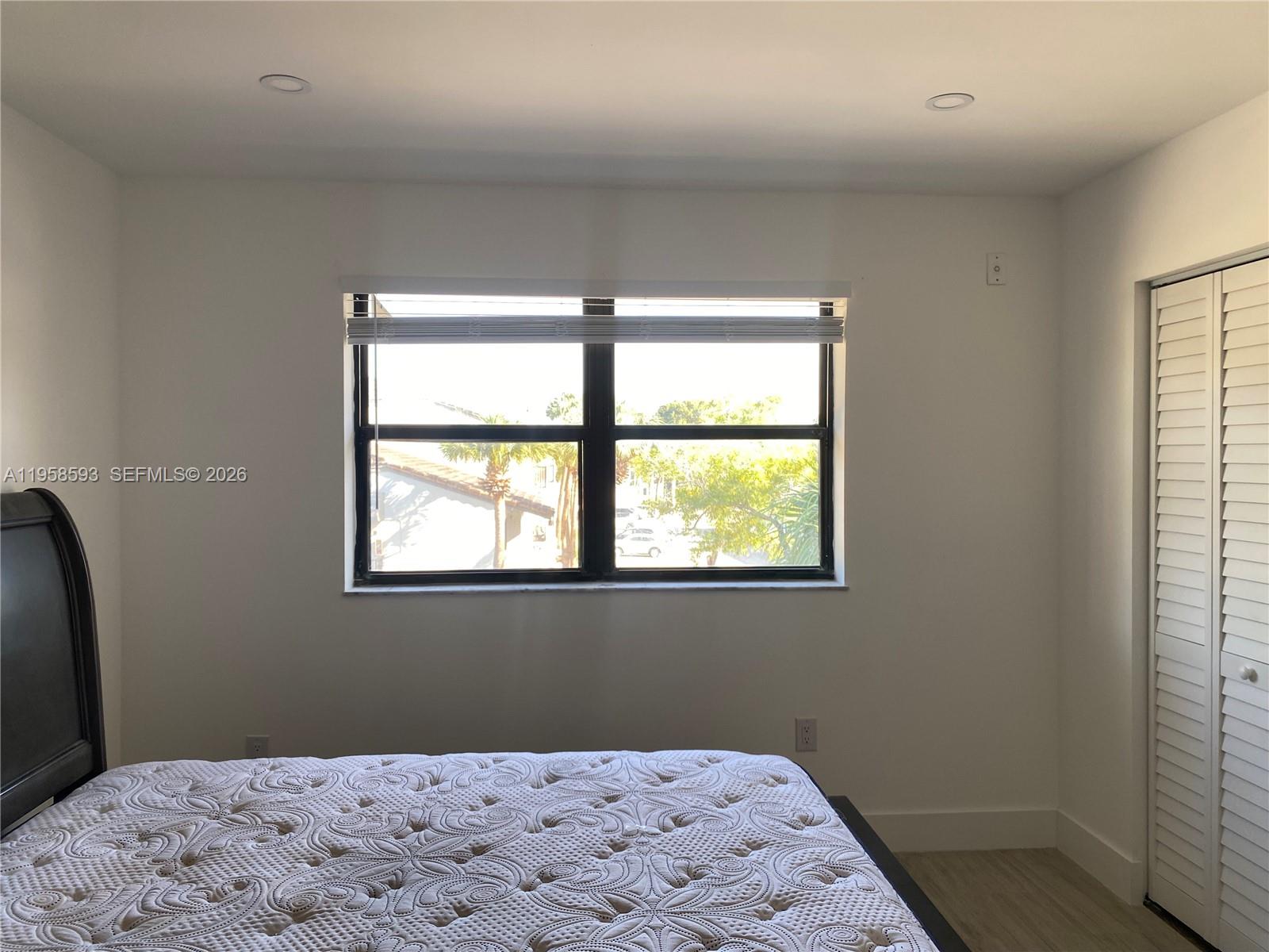 7175 Northwest 179th Street, Unit 302 Hialeah, FL 33015 - Photo 20 of 49 a bedroom with a bed window and a window