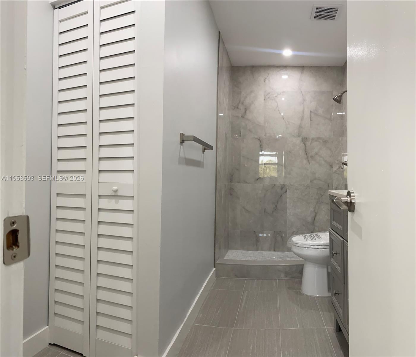 7175 Northwest 179th Street, Unit 302 Hialeah, FL 33015 - Photo 23 of 49 a bathroom with a granite countertop sink toilet and shower
