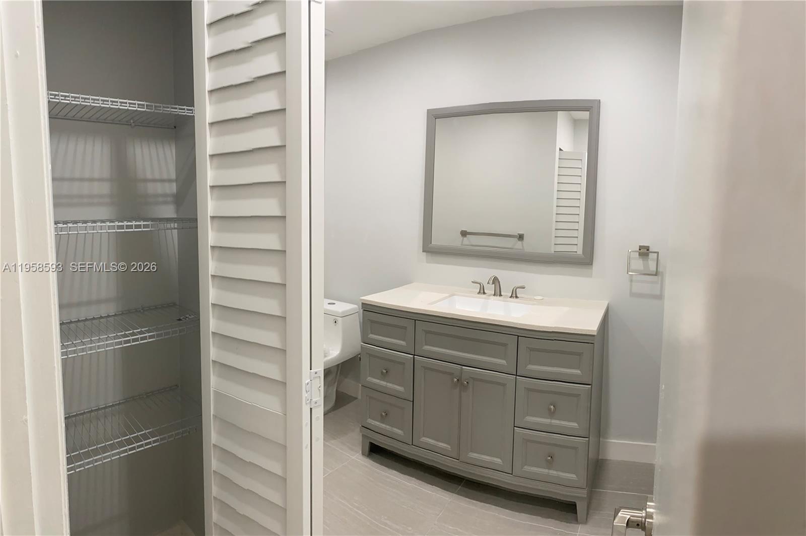 7175 Northwest 179th Street, Unit 302 Hialeah, FL 33015 - Photo 24 of 49 a bathroom with a shower sink and mirror