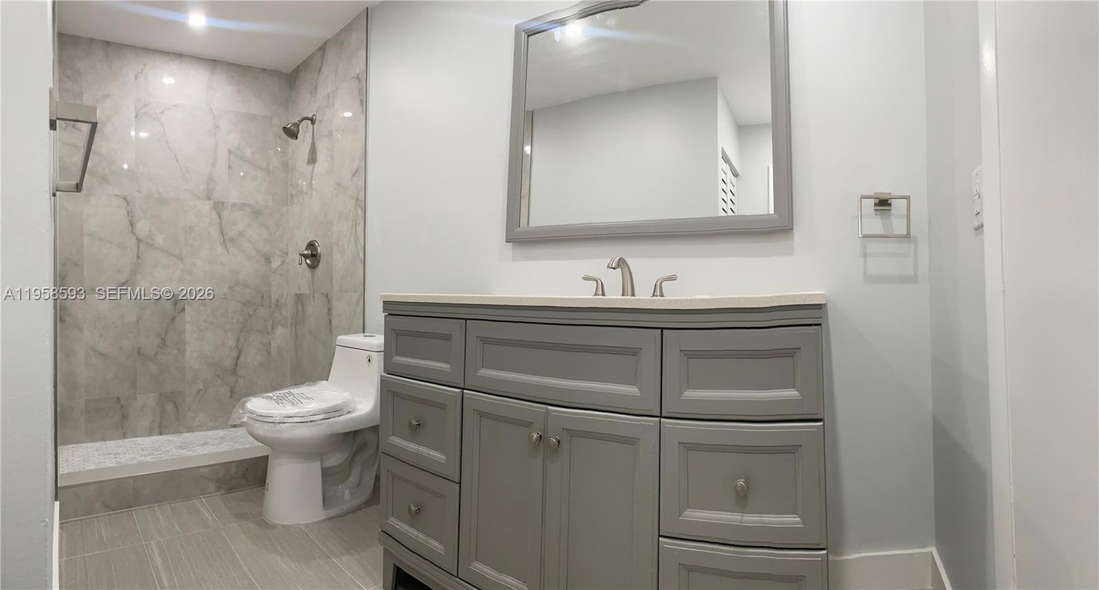 7175 Northwest 179th Street, Unit 302 Hialeah, FL 33015 - Photo 25 of 49 a bathroom with a toilet sink and mirror