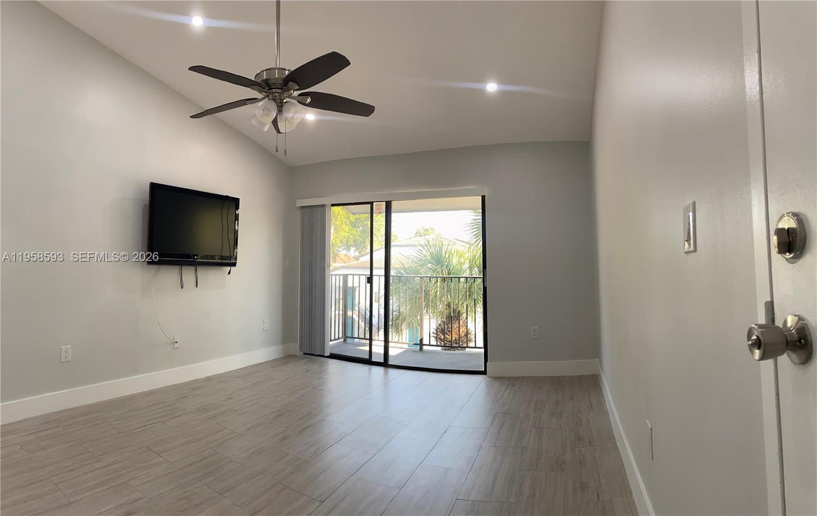7175 Northwest 179th Street, Unit 302 Hialeah, FL 33015 - Photo 32 of 49 an empty room with wooden floor fan and windows