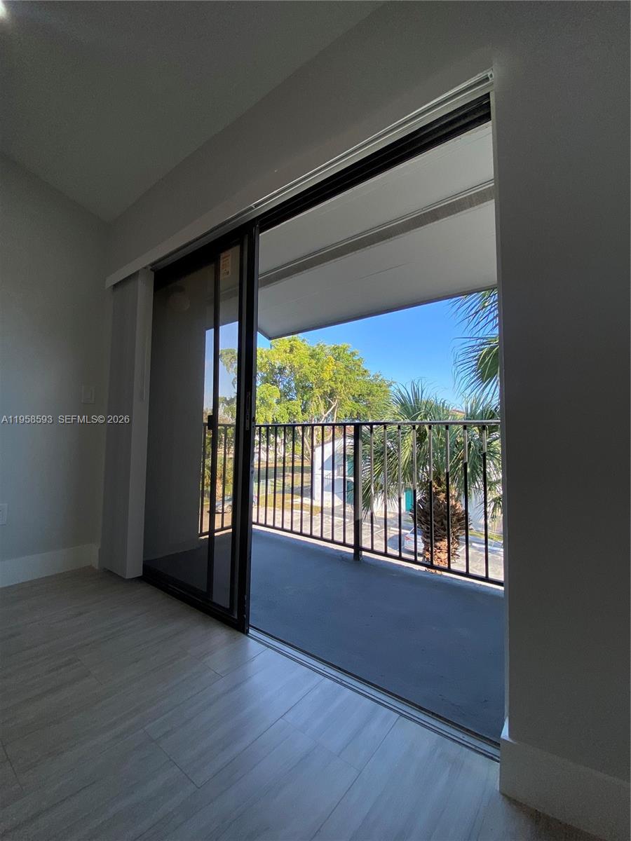 7175 Northwest 179th Street, Unit 302 Hialeah, FL 33015 - Photo 33 of 49 an empty room with wooden floor and windows
