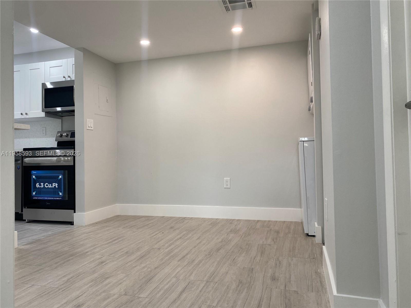 7175 Northwest 179th Street, Unit 302 Hialeah, FL 33015 - Photo 9 of 49 an empty room with wooden floor and a fireplace