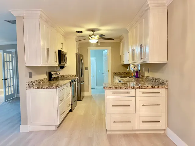 a kitchen with kitchen island granite countertop a stove and a sink