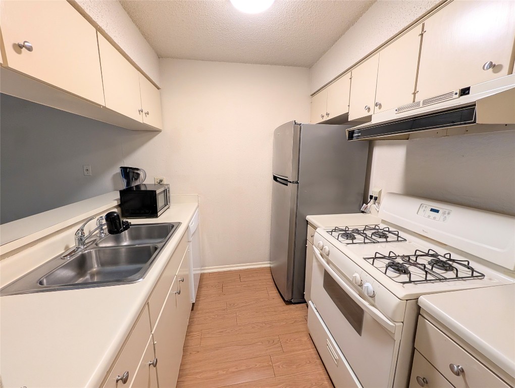 7801 Shoal Creek Boulevard, Unit 147 Austin, TX 78757 - Photo 5 of 15 a kitchen with stainless steel appliances granite countertop a sink stove and refrigerator