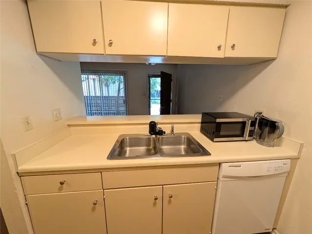 a kitchen with a sink and a washer dryer