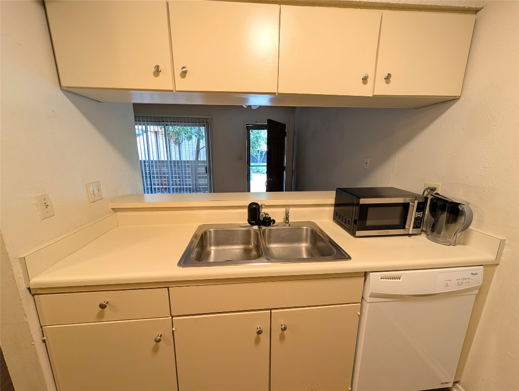 7801 Shoal Creek Boulevard, Unit 147 Austin, TX 78757 - Photo 6 of 15 a kitchen with a sink and a washer dryer