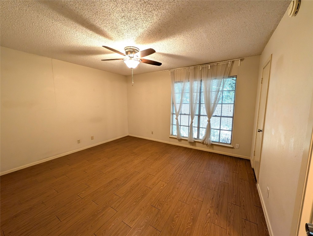 7801 Shoal Creek Boulevard, Unit 147 Austin, TX 78757 - Photo 7 of 15 an empty room with wooden floor fan and windows