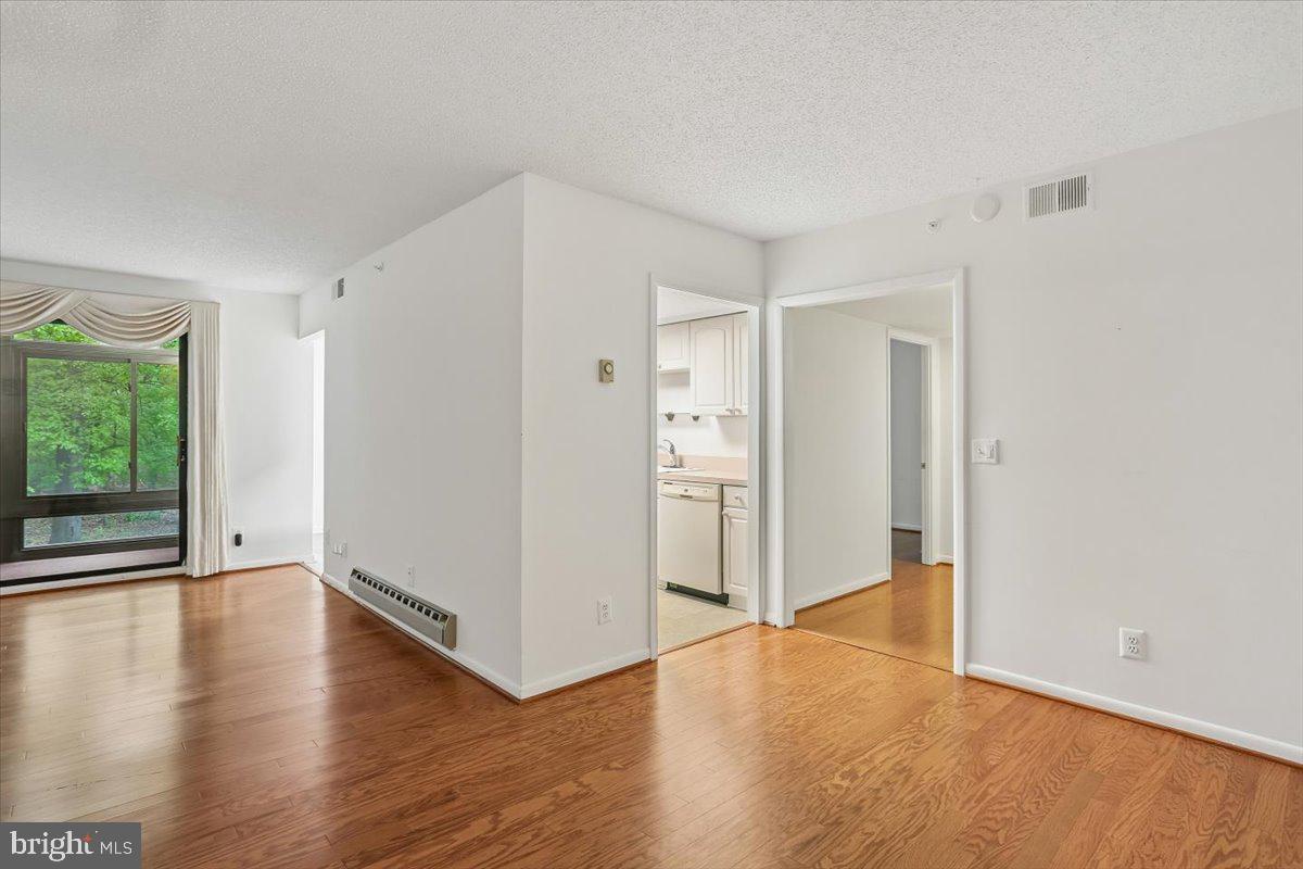 15210 Elkridge Way, Unit 912E Silver Spring, MD 20906 - Photo 12 of 48 a view of an empty room with wooden floor and a window