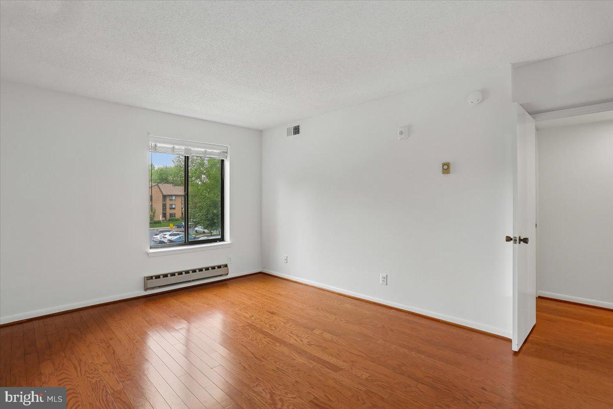 15210 Elkridge Way, Unit 912E Silver Spring, MD 20906 - Photo 28 of 48 an empty room with wooden floor and windows