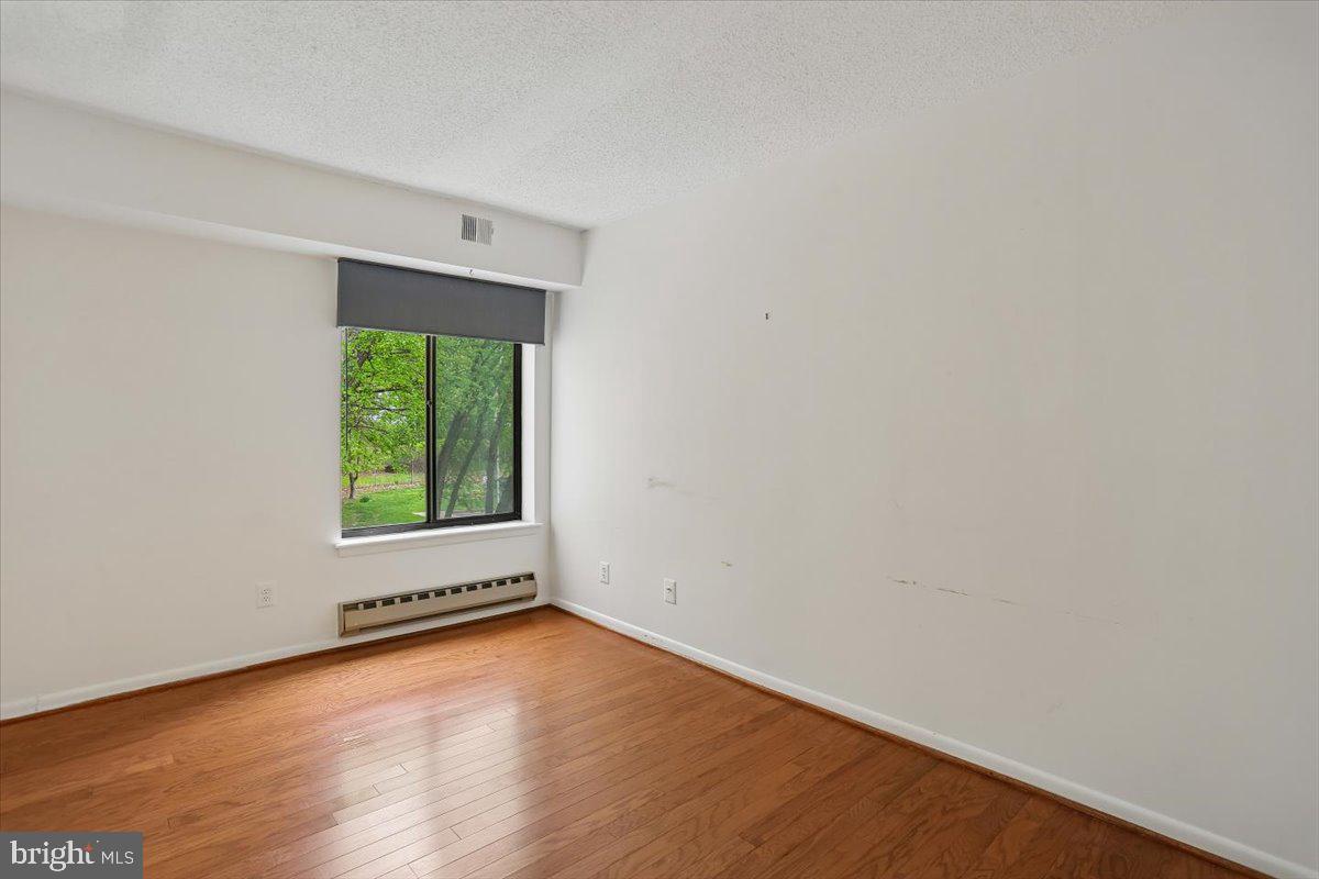 15210 Elkridge Way, Unit 912E Silver Spring, MD 20906 - Photo 34 of 48 an empty room with wooden floor and windows