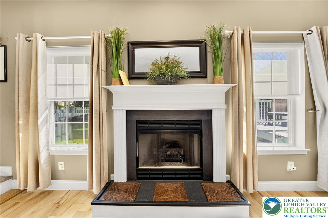 1702 Red Bud Road Quakertown, PA 18951 - Photo 23 of 68 A classic fireplace with a pristine white mantel provides a refined focal point, flanked by sun-filled windows.