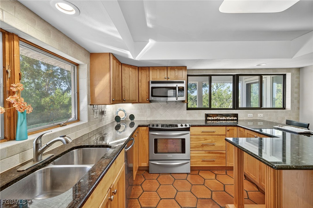 5307 Ladyfinger Lake Road Sanibel, FL 33957 - Photo 13 of 45 a kitchen with stainless steel appliances granite countertop a sink stove and cabinets
