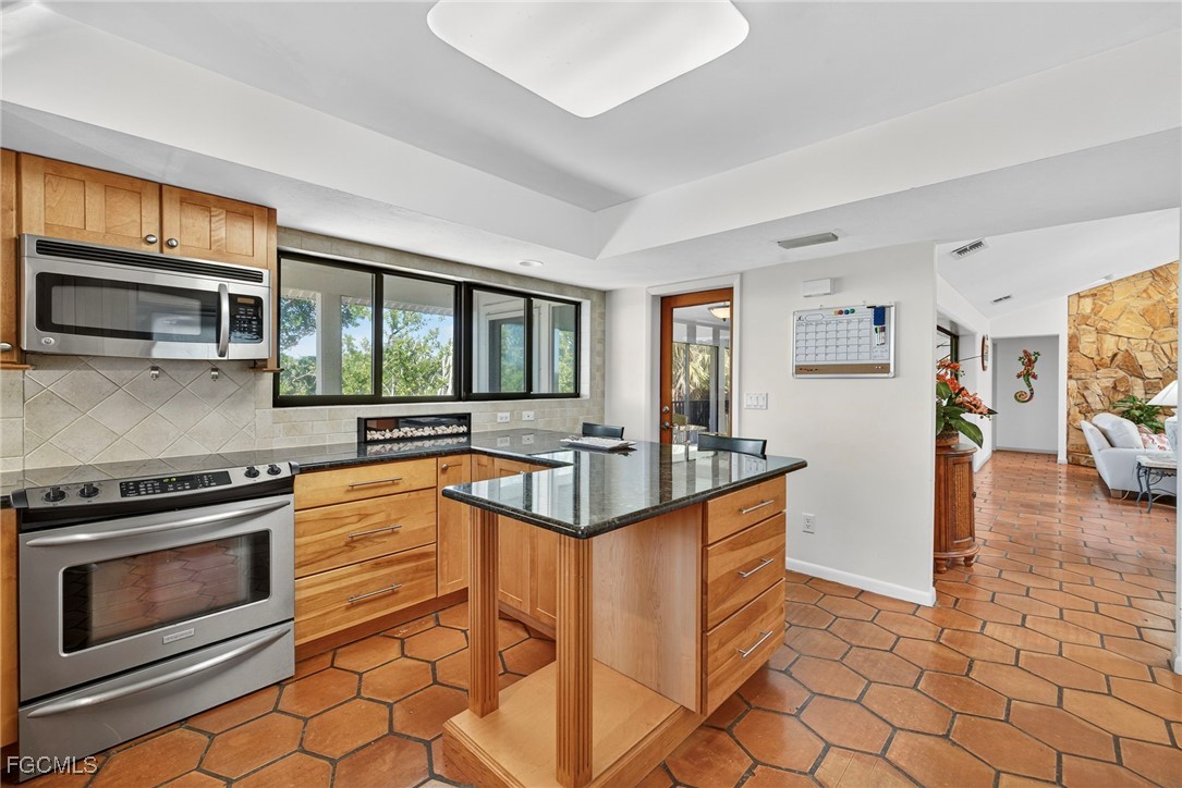 5307 Ladyfinger Lake Road Sanibel, FL 33957 - Photo 14 of 45 a kitchen with stainless steel appliances granite countertop a stove a sink and a microwave