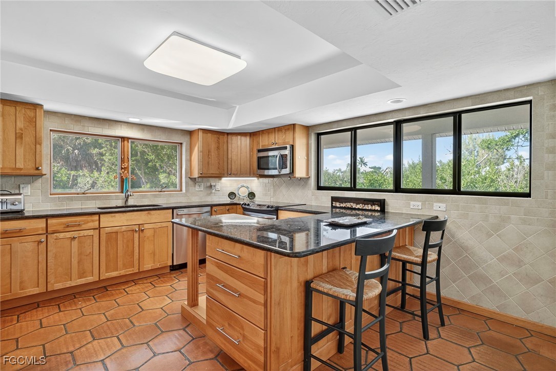 5307 Ladyfinger Lake Road Sanibel, FL 33957 - Photo 15 of 45 a kitchen with stainless steel appliances granite countertop a stove a sink and a refrigerator