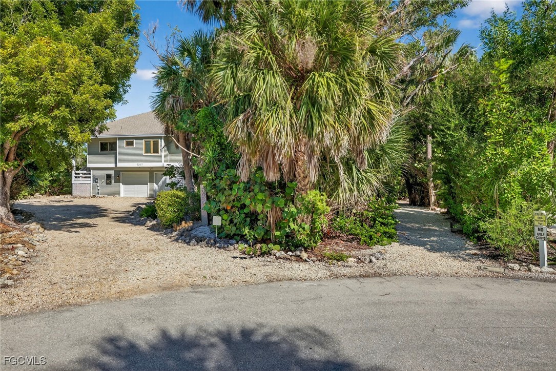 5307 Ladyfinger Lake Road Sanibel, FL 33957 - Photo 40 of 45 a front view of a house with a yard and trees
