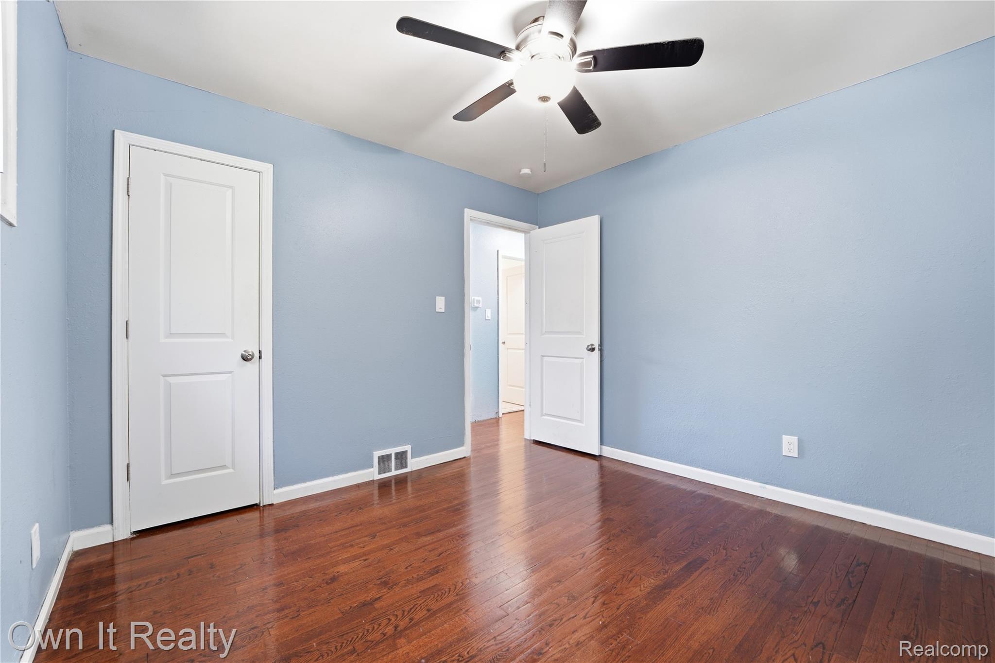 26772 Colgate Street Inkster, MI 48141 - Photo 12 of 25 Wood-finish flooring with white trim, ceiling fan, and two panel doors