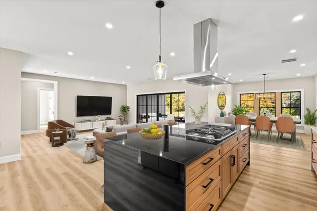 a kitchen with stainless steel appliances granite countertop a stove and a view of living room