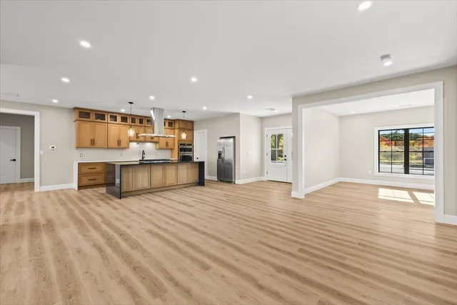 a view of large kitchen with a sink and refrigerator
