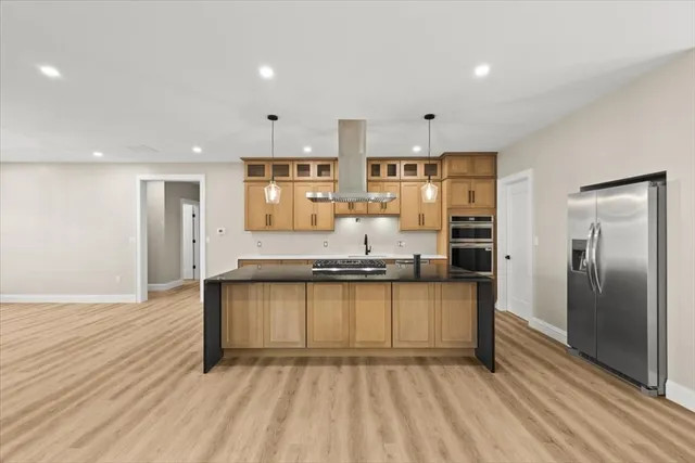 a kitchen with stainless steel appliances granite countertop a stove a sink and a refrigerator