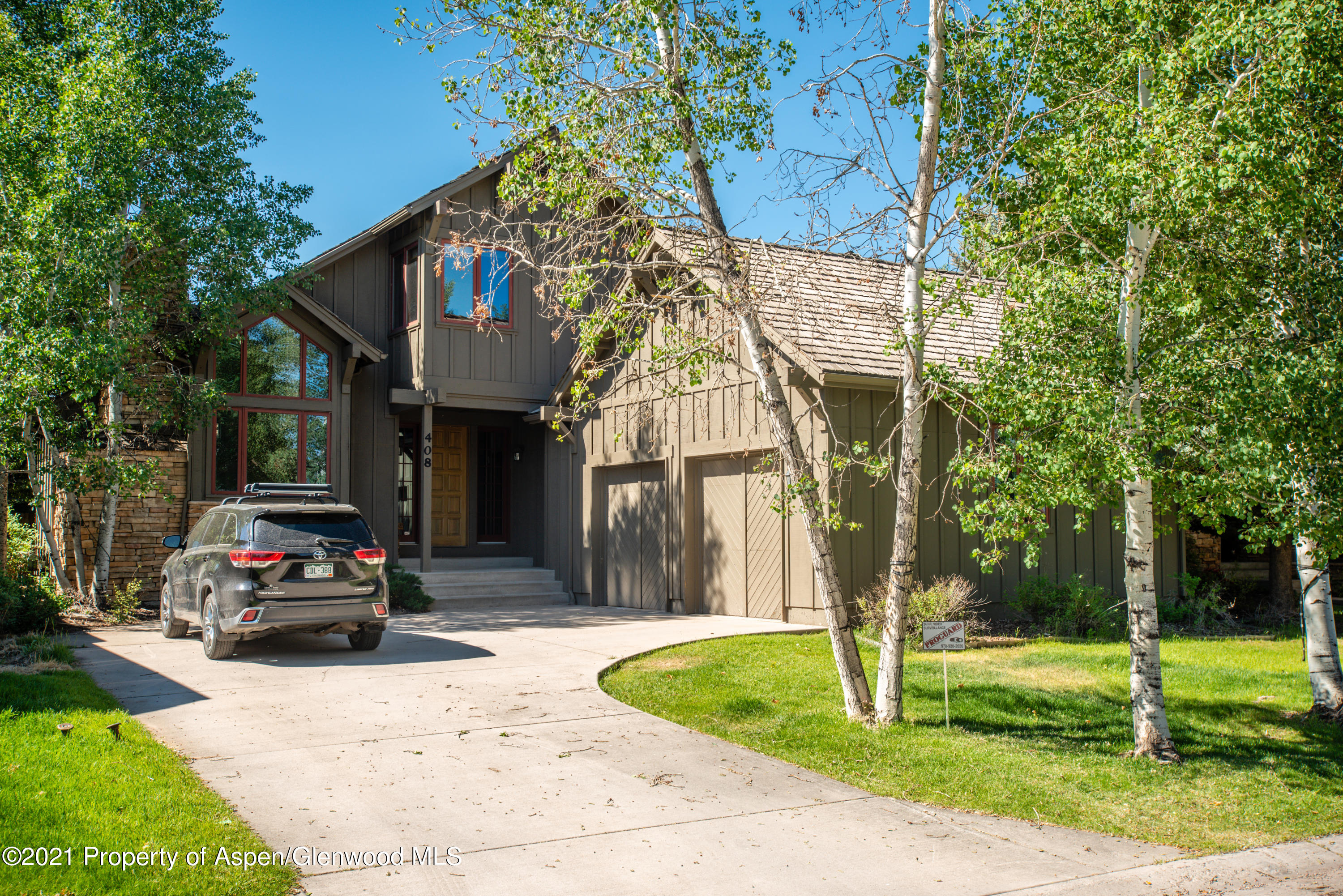 408 Settlement Lane Carbondale, CO 81623 - Photo 11 of 11 a car parked in front of brick house with a small yard