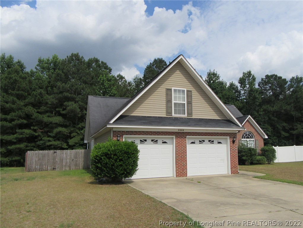 5503 Rising Ridge Drive Hope Mills, NC 28348 - Photo 5 of 6 a front view of a house with a yard and garage