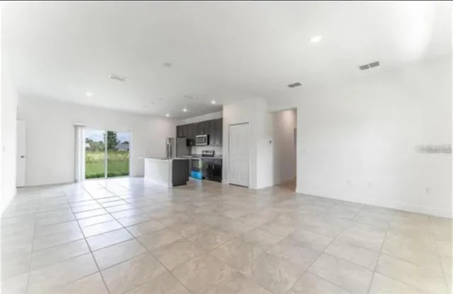 a view of a kitchen with a sink and an empty room