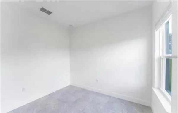 an empty room with windows and closet