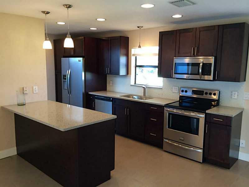 984 Southwest 4th Street Boca Raton, FL 33486 - Photo 1 of 22 a kitchen with stainless steel appliances granite countertop a sink a stove a microwave and a refrigerator