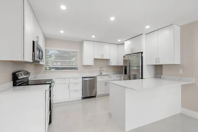 a kitchen with stainless steel appliances granite countertop a refrigerator and a stove top oven