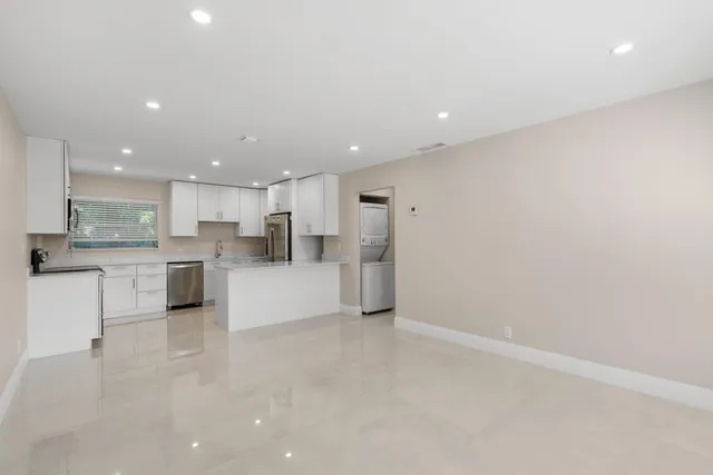 a kitchen with stainless steel appliances granite countertop a stove a sink a refrigerator a microwave and cabinets