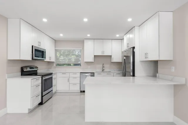 a kitchen with white cabinets and appliances