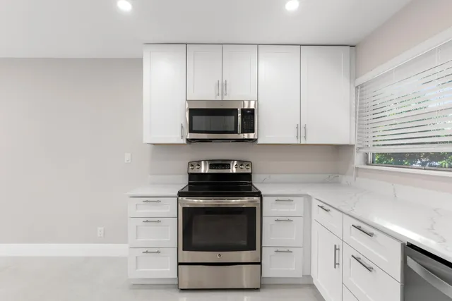a kitchen with white cabinets and stainless steel appliances