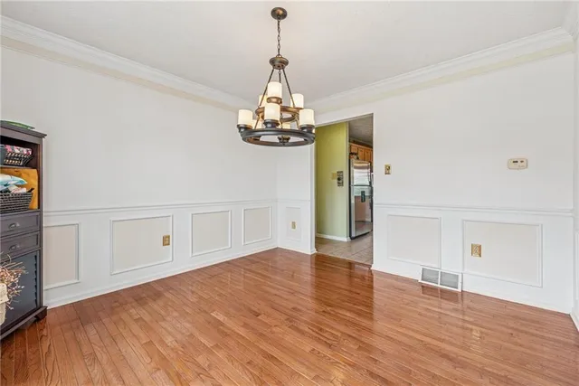 a view of an empty room with wooden floor and windows