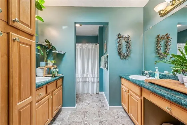 a bathroom with a granite countertop sink a mirror and a shower