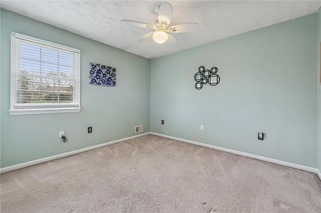 an empty room with a window and a fan