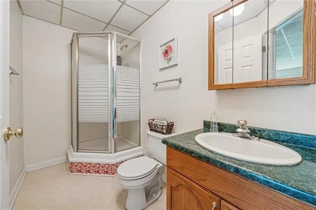 a bathroom with a granite countertop sink toilet and shower