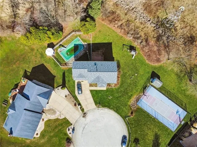 an aerial view of a house with a yard and trees