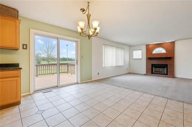 a view of an empty room with a fireplace and a window