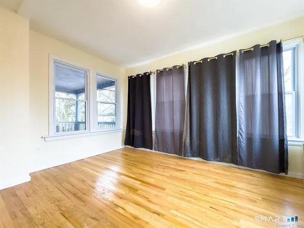 a view of a room with wooden floor and a window