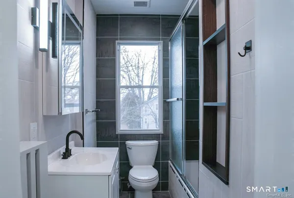 a bathroom with a toilet a sink and a window
