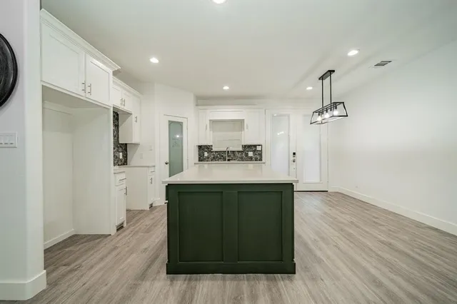 a view of a kitchen with refrigerator and wooden floor