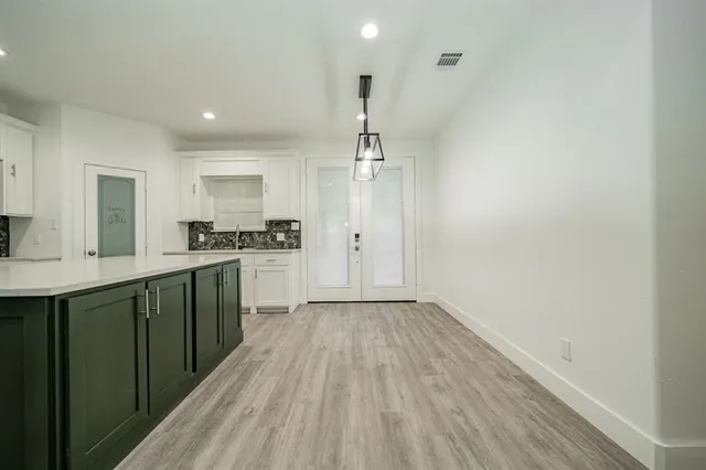 a kitchen with a sink wooden floor and stainless steel appliances