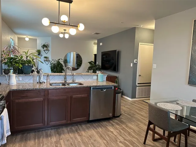 a kitchen with stainless steel appliances granite countertop wooden floors and granite counter tops