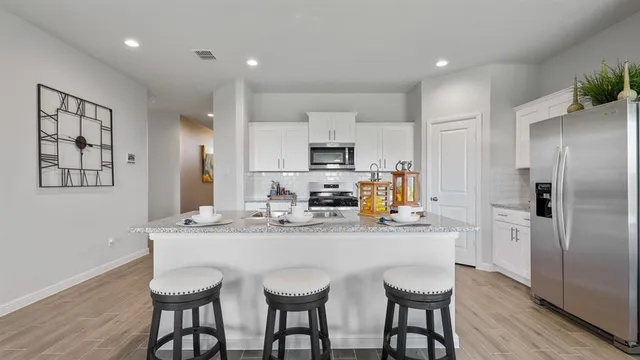 a kitchen with stainless steel appliances granite countertop a sink and a stove